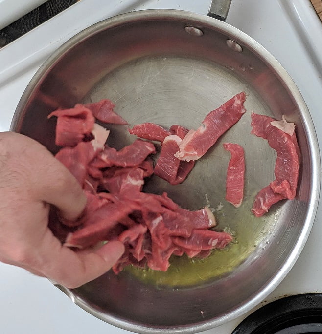 Sliced beef browning in the pan