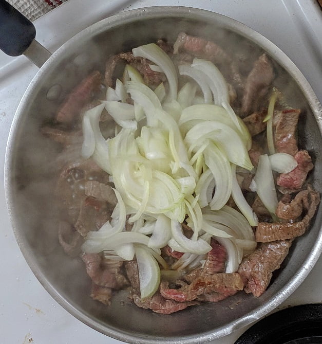 Mushrooms and garlic added to the pan