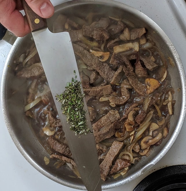 Adding beef stock to the pan