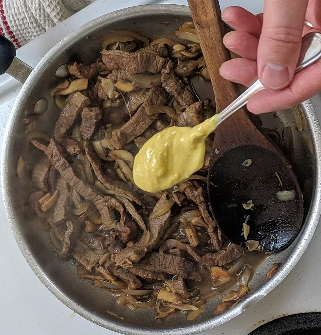 Adding Dijon mustard to the stroganoff