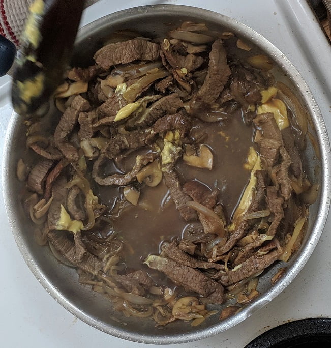 Whisking Dijon mustard into the sauce