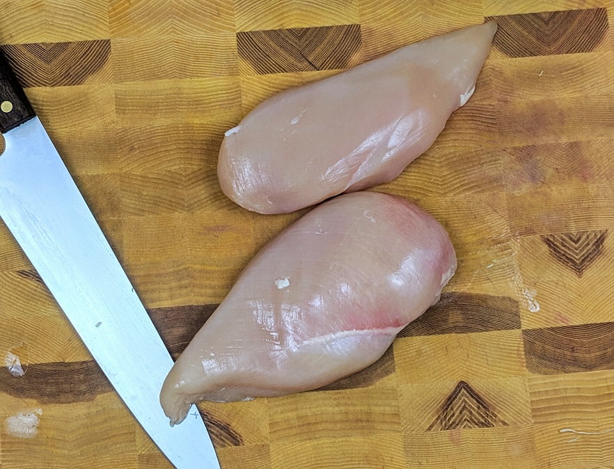 Raw chicken breast on a cutting board