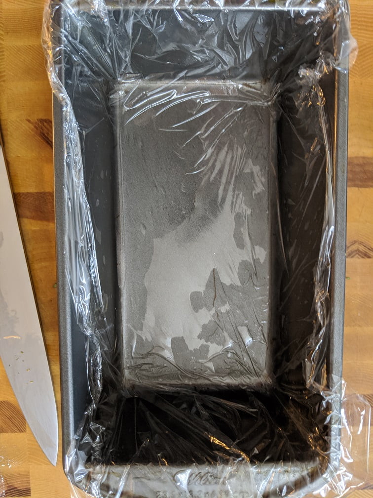 P&acirc;t&eacute; mixture pressed into a lined loaf pan ready for baking