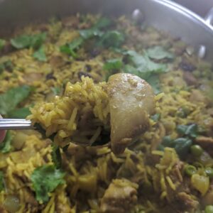 A fork full of curried rice pilaf with chicken