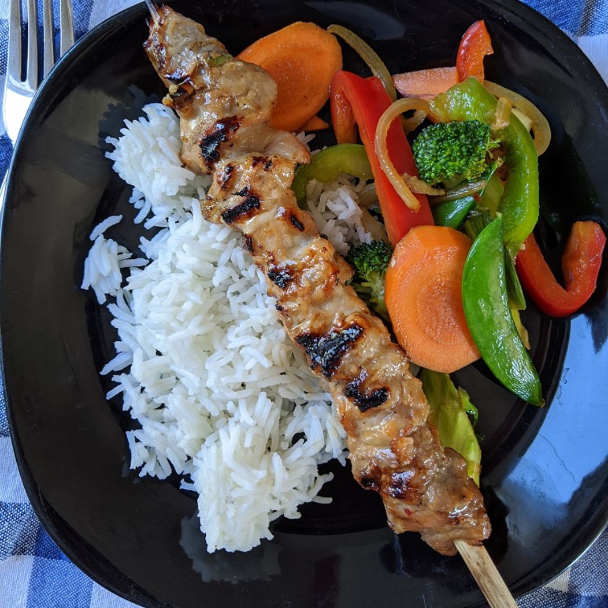 Pork satay skewer with stir fried vegetables and rice