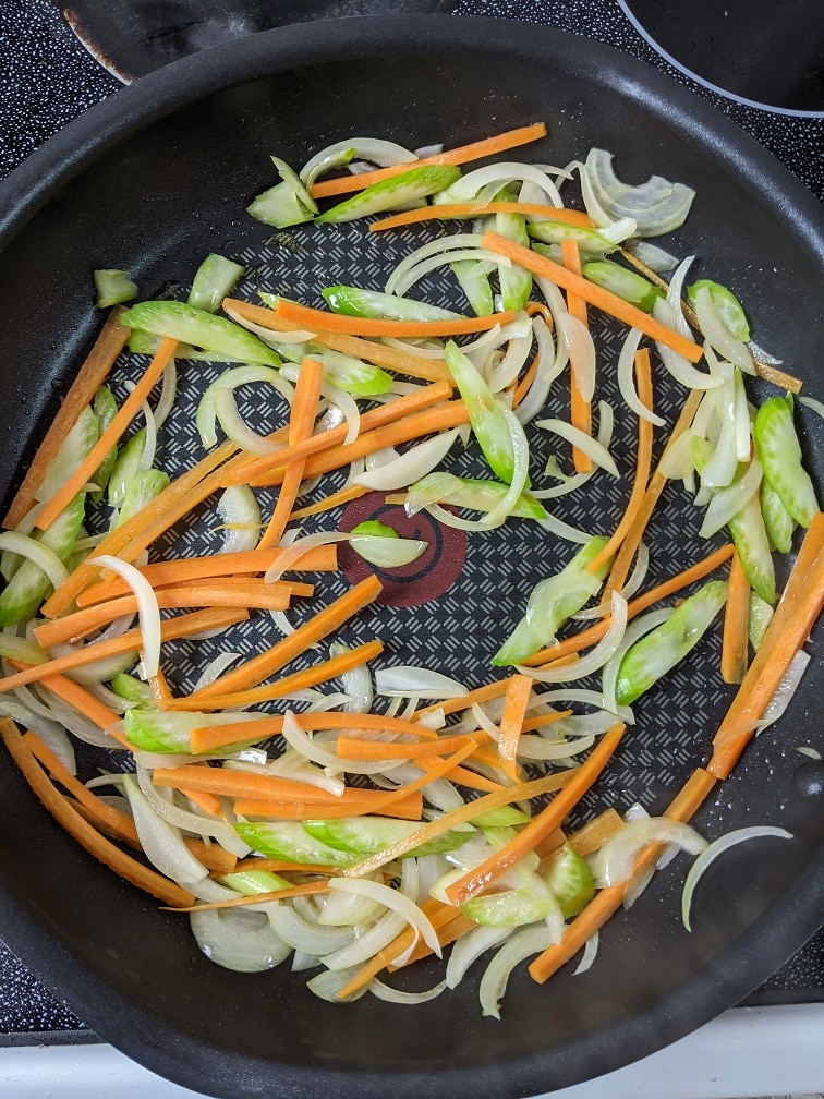 Onion, celery, and carrot stir-frying in the pan