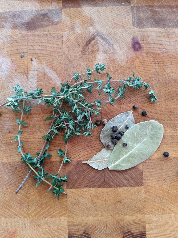 Bay leaves, peppercorns, and thyme added to the stock pot