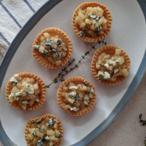 Mini tarts stuffed with caramelized pears and topped with blue cheese