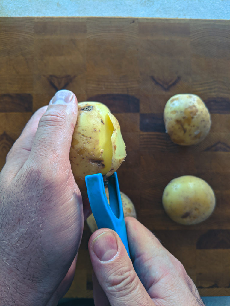 Peeling yellow potatoes with a vegetable peeler