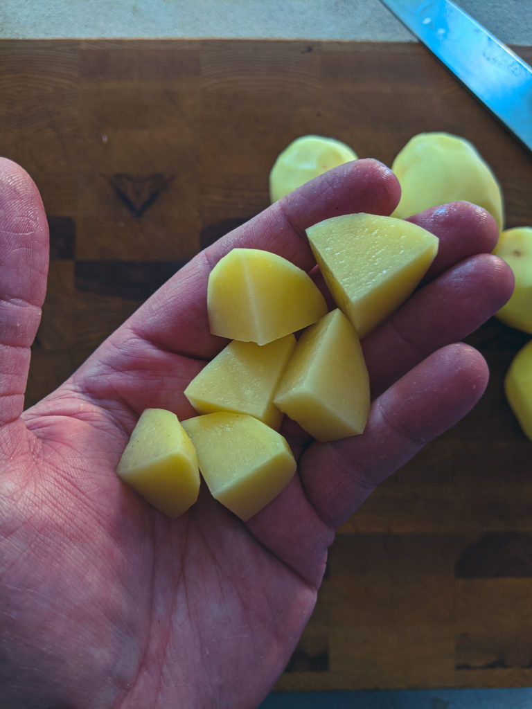 Dicing peeled yellow potatoes into even pieces