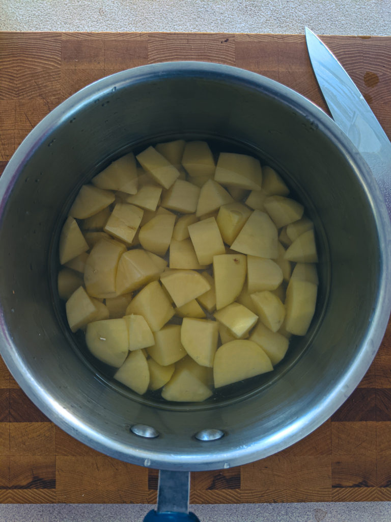 Cloudy starch water draining from rinsed potatoes