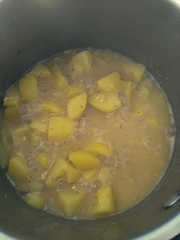 Fully cooked potatoes with stock reduced in the pot