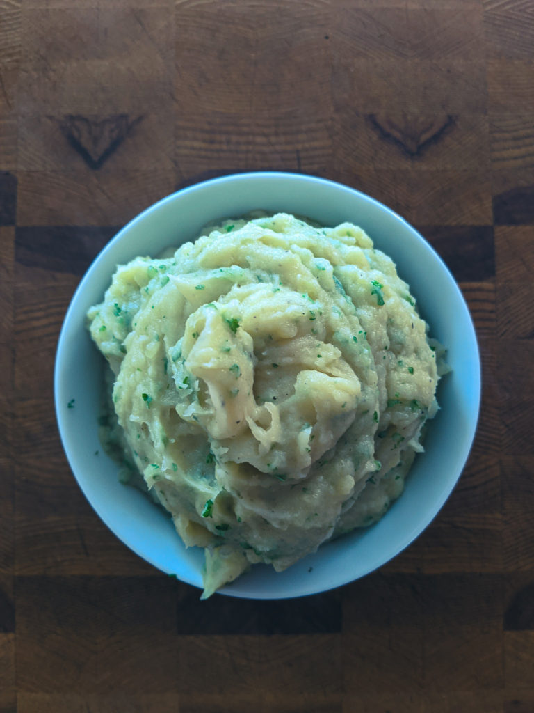 Creamy mashed potatoes topped with fresh parsley
