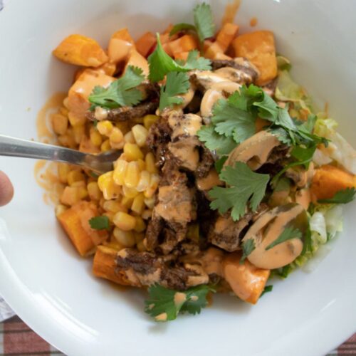 Spicy beef bowl with corn, rice, sweet potato, cilantro and chipotle mayo